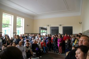 Im Gebäude der Mineralquell hören die Menschen aufmerksam zu.