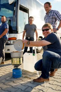 Bockwürsten warm machen auf einem Campingkocher.